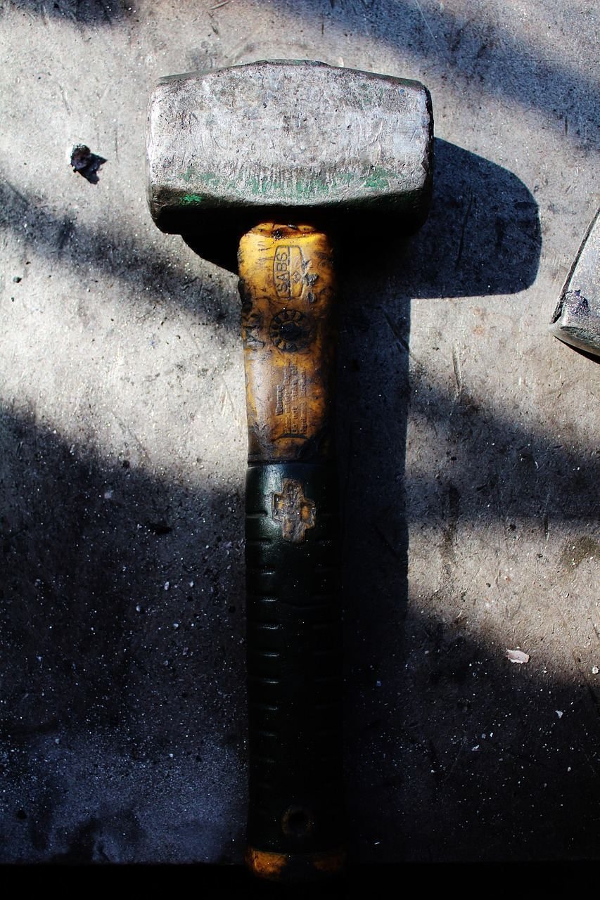Close-up of a technician working on an air conditioning unit with tools on a sunny day.